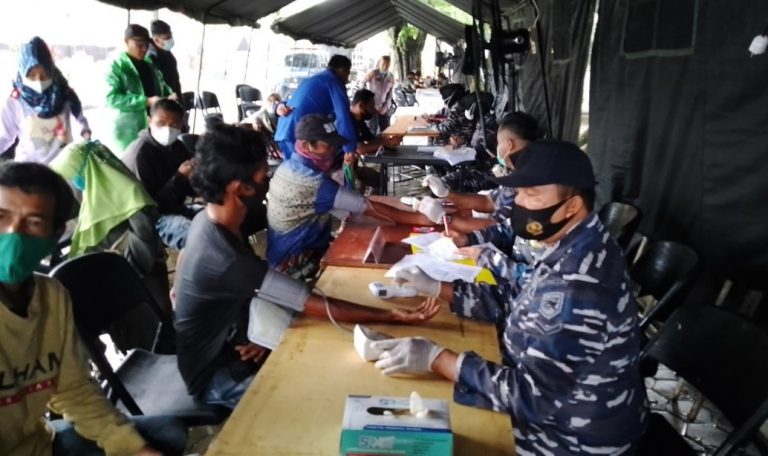 Nakes Lantamal II Tetap Beri Pelayanan Vaksinasi di Tengah Kota Diguyur Hujan